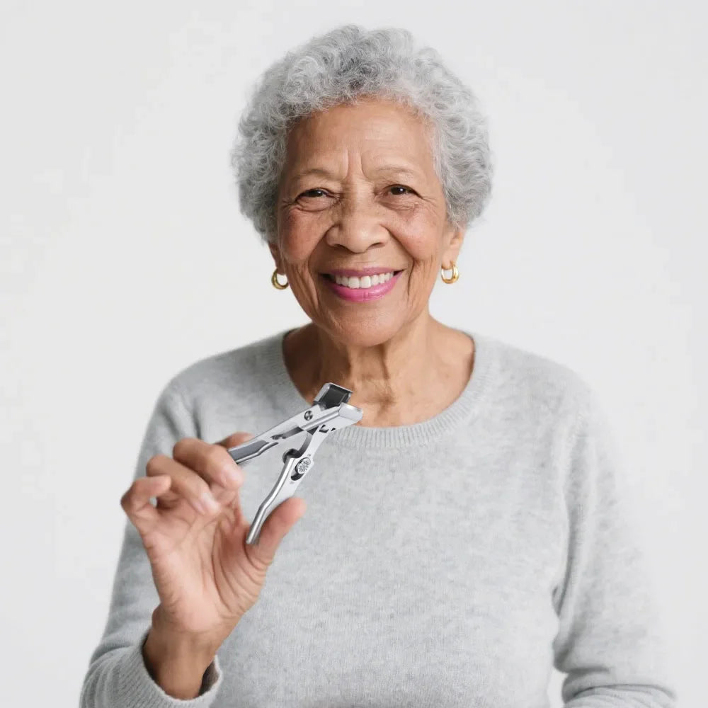 Smiling senior woman holding stainless steel nail clippers against a white background