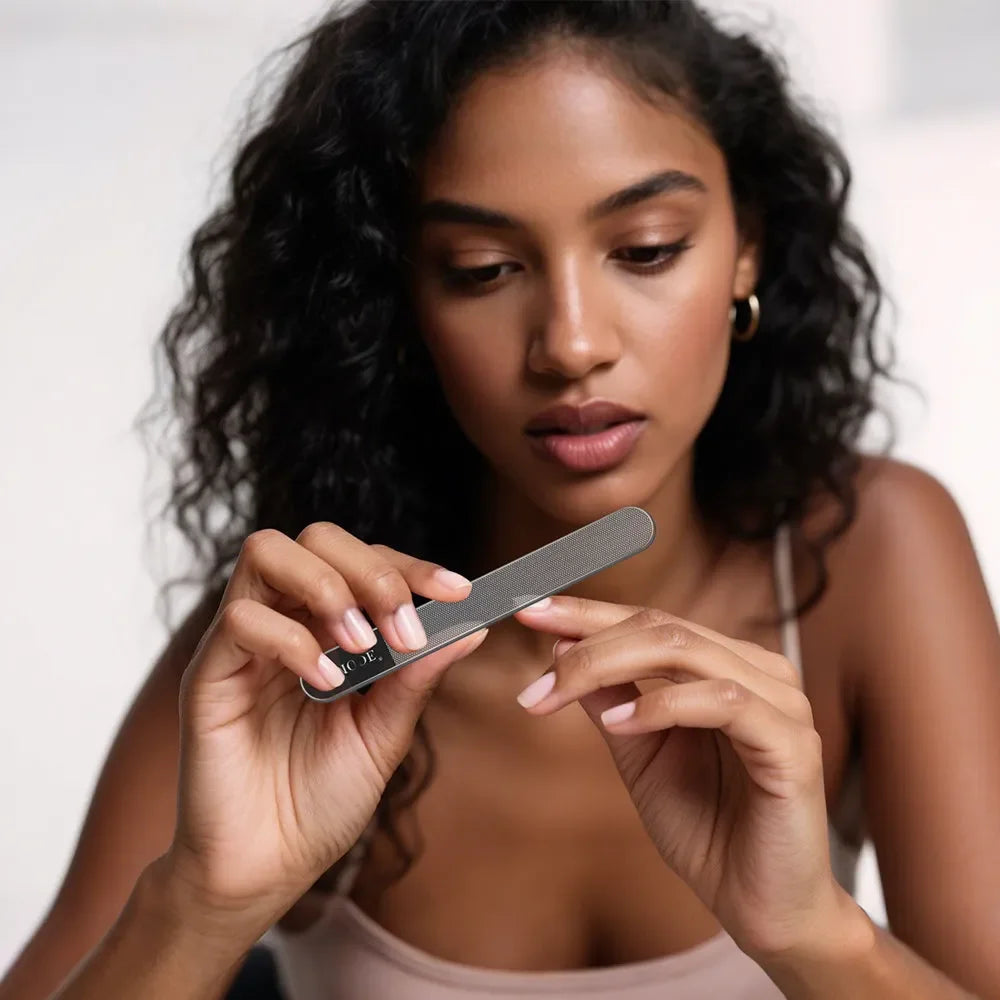 Woman using a nail file for manicure, close-up of hands and nail care tool