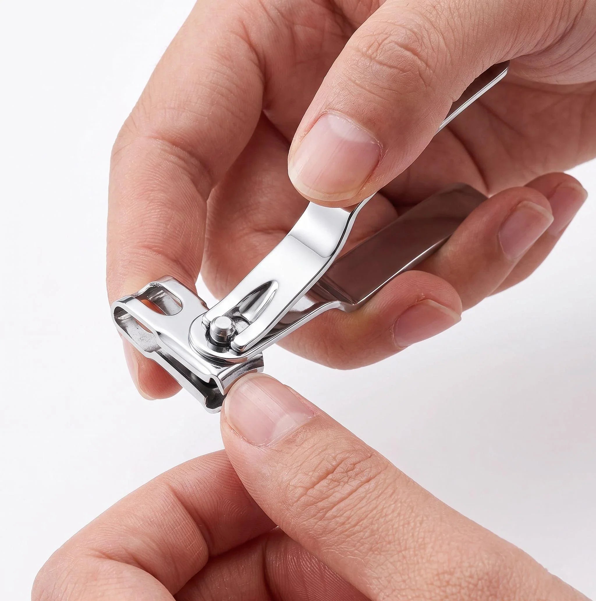 Close-up of a hand using a high-quality stainless steel fingernail clipper with integrated nail file to trim a fingernail for clean, precise cuts