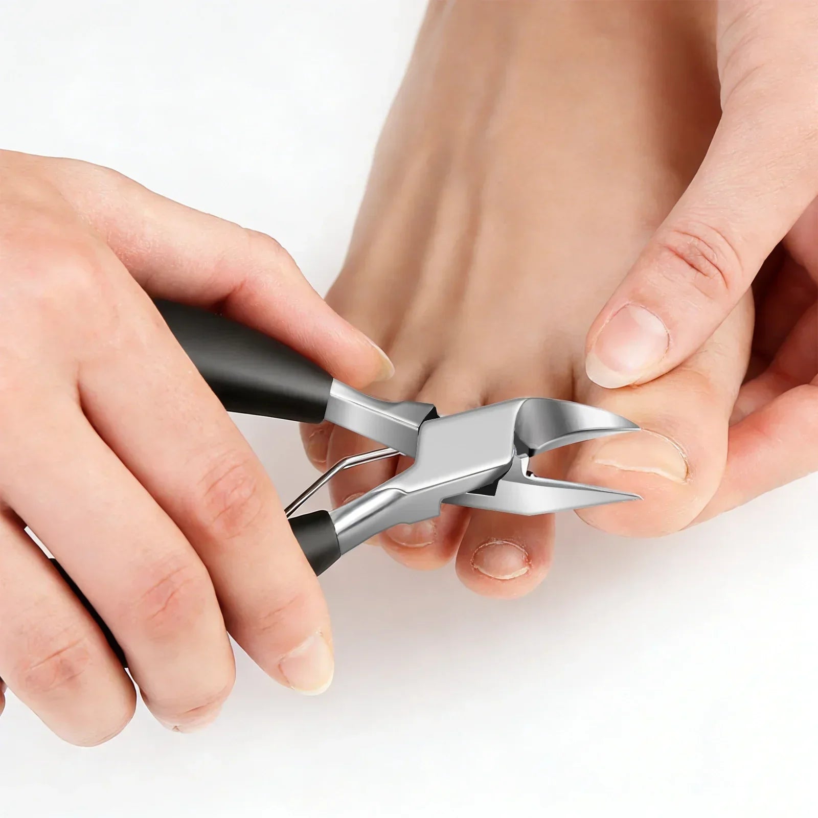 Stainless steel toe nail clippers trimming thick toenails on a person's foot