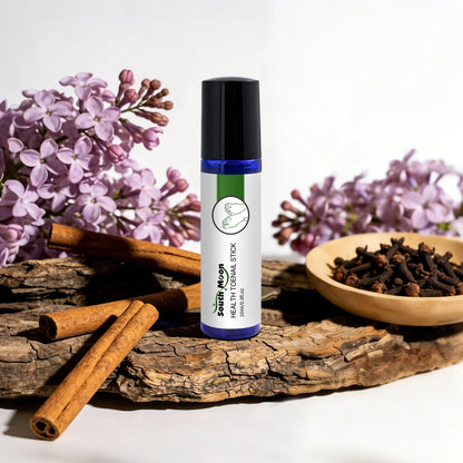 Herbal toenail treatment stick with cinnamon, cloves, and lilac flowers on rustic wood.