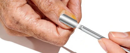 Hand using a stainless steel nail tool to clean under fingernail, close-up