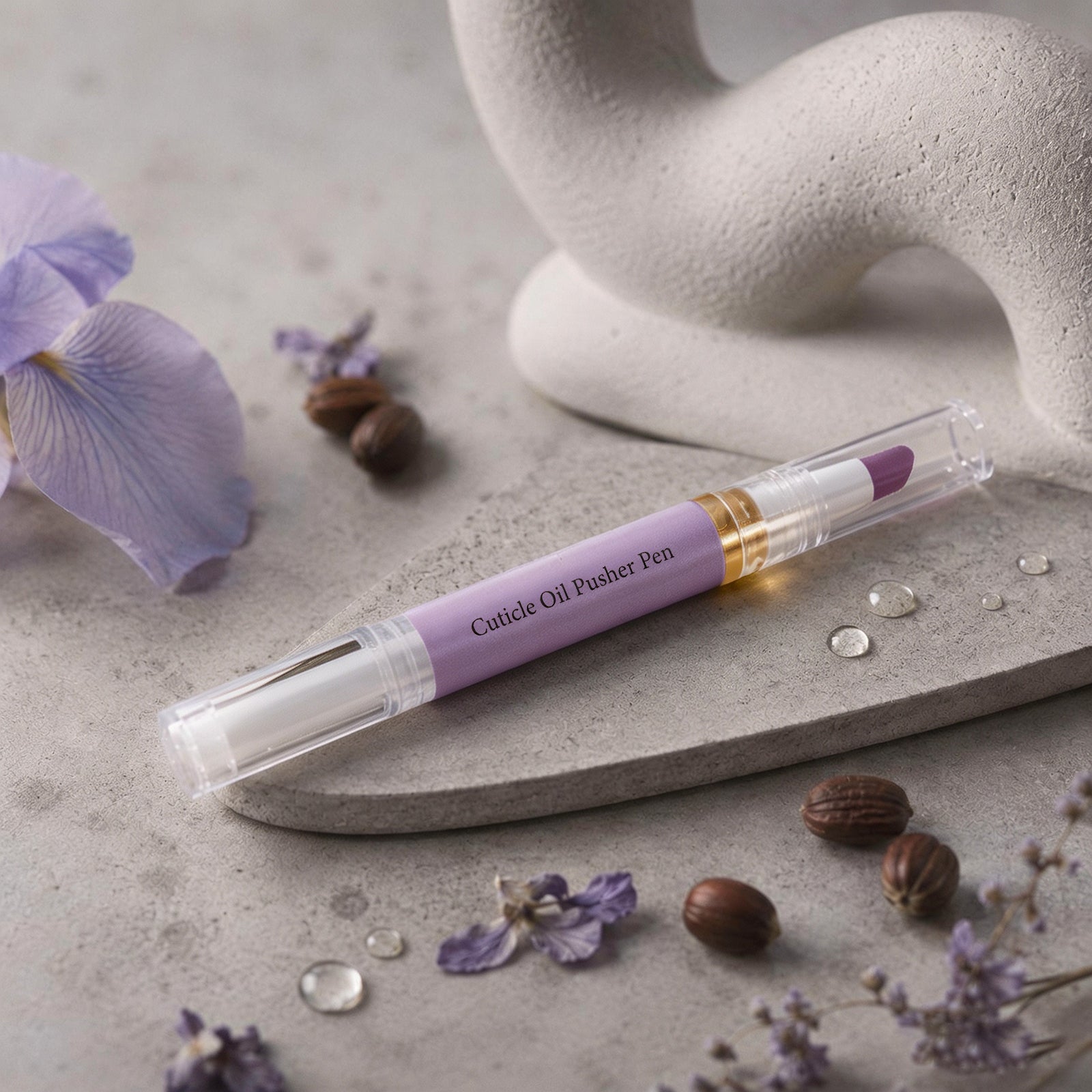 Cuticle oil pen in artistic flatlay composition on stone surface with water droplets and purple blooms