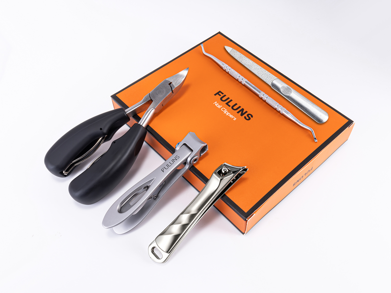 Full German-made nail clipper set arranged around the branded orange gift box, including multiple clippers, a glass nail file, and cuticle tool
